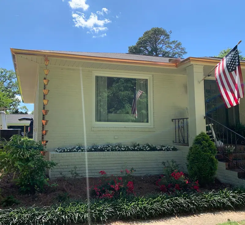 Copper gutter and copper rain chain on a painted-brick ranch home, a Mosqueda Construction gutter job near Birmingham, AL