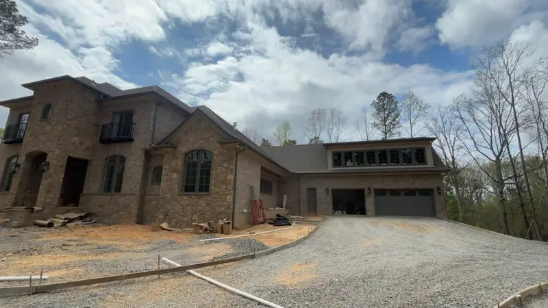 New brick and stone custom home with bronze gutters and downspouts, a Mosqueda Construction gutter job on new construction